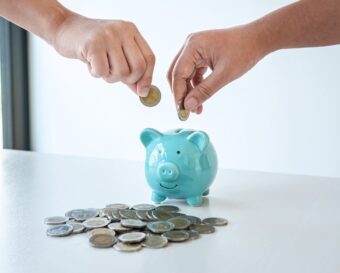 Image of hands putting coins into piggy bank planning growing sa